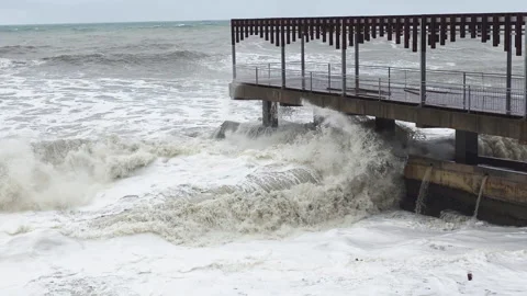 Raging ocean crashes structure violently. Stormdriven waves batter harbor Vídeo Stock 330264766