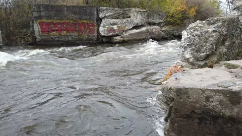 Raging river flowing through to rocky banks Stock Footage 143197686