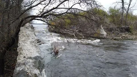 Raging river flowing through to rocky banks Stock Footage 143198037