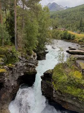 A raging river flows down from the mountains of Norway. Stock Photos