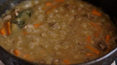 Ragout of meat and vegetables is cooked in a metal pan, close-up Stock Footage 128649555