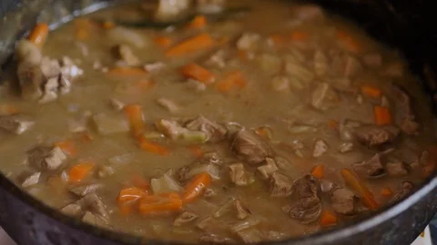 Ragout of meat and vegetables is cooked in a metal pan, close-up Stock Footage 128649707