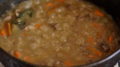 Ragout of meat and vegetables is cooked in a metal pan, close-up Stock Footage 128651377