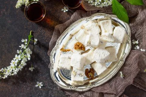 Rahat Lokum with walnuts on the kitchen table. Turkish and Arabic sweets. Stock Photos