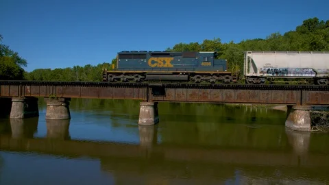 Rail bridge over a wide river and a train passes over at 60fps Stock-Footage 128662439