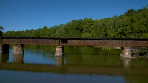 Rail bridge over a wide river and a train passes over at 60fps - half speed Stock-Footage 128662600