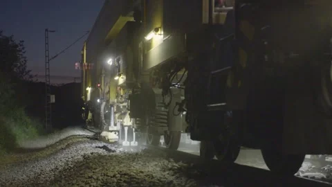 Rail Maintenance Vehicle Operating at Night with Work Lights on Railway Tracks Stock Footage 334055253