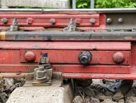 Rail pad secured with red fastener prevents metal contact and ensures safety Stock Photos