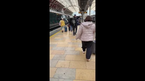 Rail passengers walking along a platform to catch their train Stock Footage 335218956