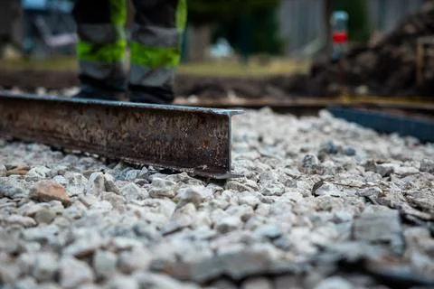Rail replacement on ballast bed with worker in high vis pants Photos