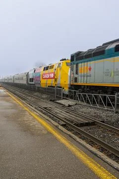 Via Rail train of Canada passing through station on a foggy day Stock Photos