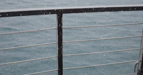 Railing on deck over ocean on a rainy day Stock Footage 313100052