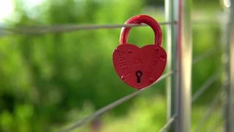 On the railing hangs a wedding lock of red in the form of a heart. Stock Footage 199597344