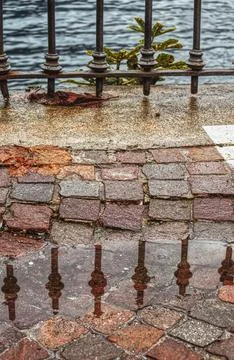 A railing reflected in a puddle. Foto stock