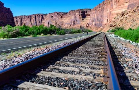 Railroad at the bottom of a canyon next to Layered Geological Formations of.. 스톡 사진