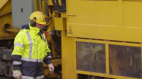 Railroad construction worker operating a large track laying machine Stock Footage 52317879