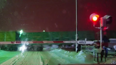 Railroad crossing, freight train in snowfall, blizzard, snowstorm weather 動画素材 59697678
