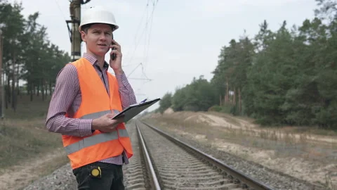 Railroad engineer talking on the phone with the chief engineer. Stock Footage 146369663