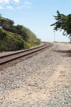 Railroad tracks curing around a bend on a gravel path Stock Photos