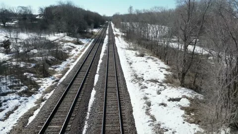 Railroad train tracks through a winter field with snow and trees Stock Footage 237720675