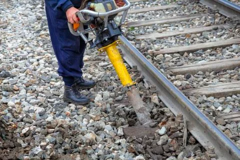 Railroad worker using vertical vibration tamper Stock Photos