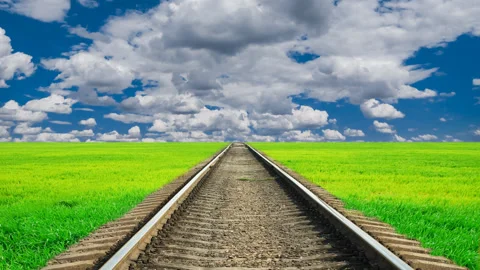 Railway among green fields under a blue cloudy sky Video stock 152385806