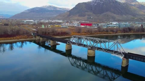 Railway bridge over the river at dawn with mountains in the background. Видео 145164800
