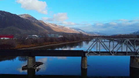 Railway bridge over the river at dawn with mountains in the background. Vídeos de archivo 145164880