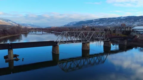 Railway bridge over the river at dawn with mountains in the background. Видео 145165087