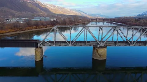 Railway bridge over the river at dawn with mountains in the background. 스톡 동영상 145165210
