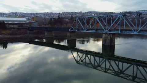 Railway bridge over the river at dawn with mountains in the background. Vidéo 145165438