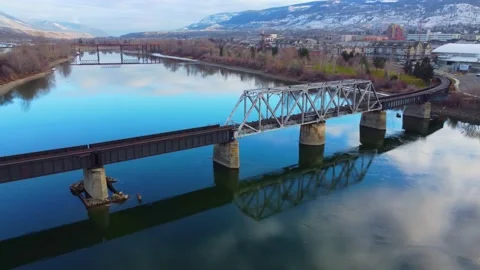 Railway bridge over the river at dawn with mountains in the background. Vídeos de archivo 145165642