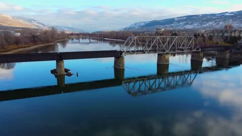 Railway bridge over the river at dawn with mountains in the background. 動画素材 145165837