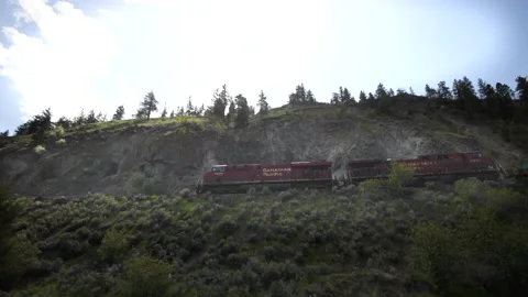 Railway - Canadian Pacific train pullos along a cliff in B.C. - low angle, 4k Stock Footage 191627909