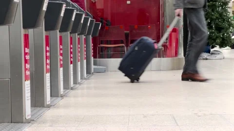 Railway Commuters Pulling Suitcases and Luggage Through Ticket Barriers Stock Footage 166024820