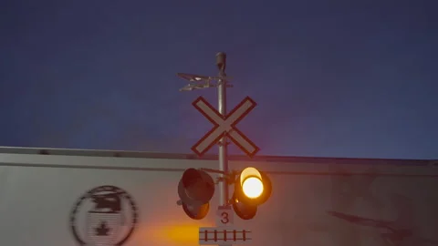 Railway crossing lights with cargo train passing by Stock Footage 225406878