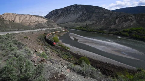 Railway with deisel engine curves along river in B.C., 4k Stock Footage 191628568