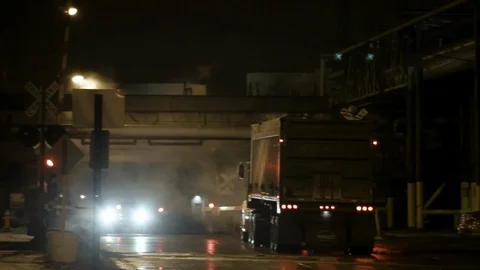 Railway gates open at crossing with dump truck and pick up truck at night Stock Footage 89945351
