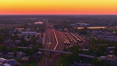 Railway hub operating under a vibrant sunset creating long transport lines Stock Footage 334365402