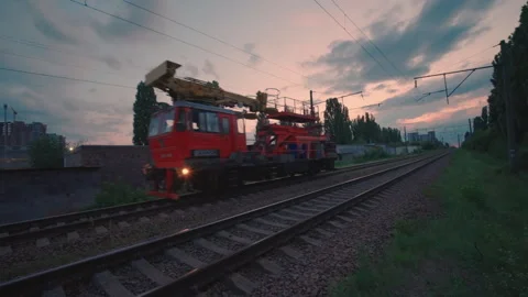 Railway Maintenance Crane Train Moving Along Tracks at Dusk | Industrial Rail Stock Footage 341999231