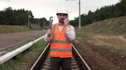 A railway maintenance crew worker talks on the radio to the foreman. Stock Footage 262642736