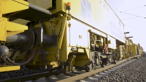 Railway Maintenance Machine Moving Along Tracks on Sunny Day, Close Side View Stock Footage 334053773
