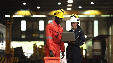 Railway technicians and engineers inspect the trains in train repair station Stock Footage 274873316