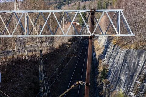 A railway track runs through a deep mountain cutting with a steel overhead Stock Photos