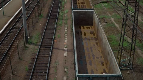 Railway tracks, freight train with empty cars, the camera rises, in the Stock Footage 91695219