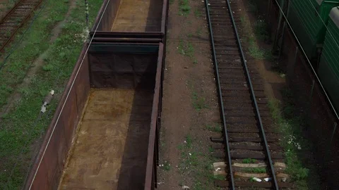 Railway tracks, freight train with empty cars, the camera rises, against the Stock Footage 91695369