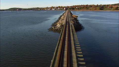 Railway tracks passing through the river, houses and autumn trees in background Stock Footage 109134566