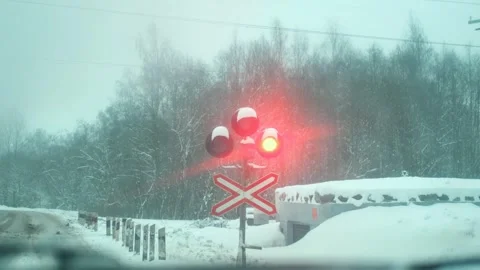 The railway traffic light flashes red across the crossing Stock Footage 296125110
