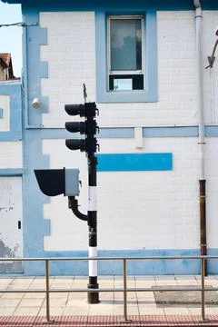 Railway traffic light showing stop signal on a level crossing, near a white a 写真素材