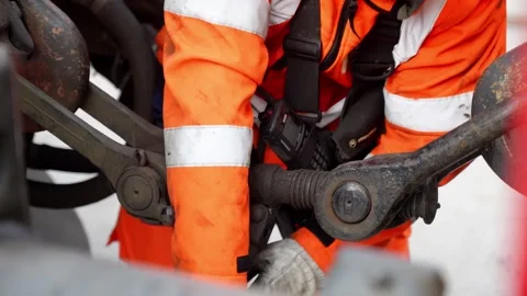 Railway worker manually opening and uncoupling heavy freight train mechanical Stock Footage 337976267